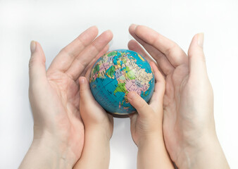  Hands of mother and child holding a globe