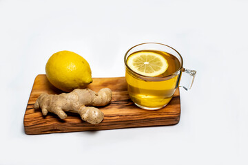 lemon, ginger and a cup of lemon tea on an olive board on a white background