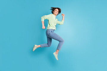 Full size profile photo of optimistic short hairdo girl run jump wear lime sweater jeans sneakers isolated on teal color background