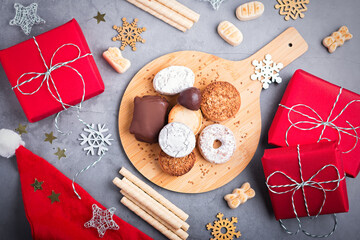 Traditional Spanish Christmas sweets turron, polvorones, mantecados with Christmas decor and red gift boxes on grey table top, copy space