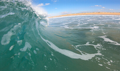 Barrel and tube forming wave seen from a surfers perspective in El Palmar, Spain