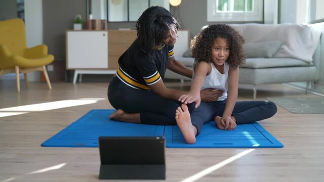 Mother and daughter doing fitness exercices at home