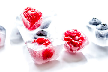 fresh blueberry and raspberry in ice on table background