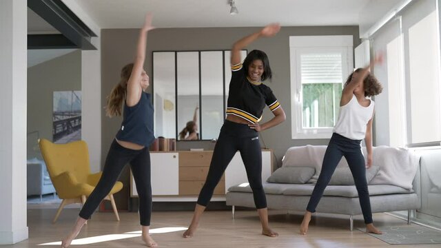 Woman with girls doing fitness exercices at home