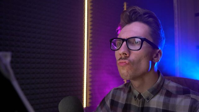 A young guy with glasses is exploring the Internet. guy with a stupid face reads social networks. Concept: news, internet, user, gamer, streamer