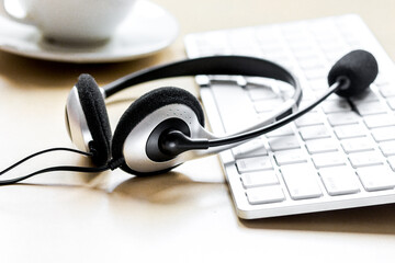 Office desk with headset and keyboard brown background