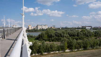 
View from the bridge to the river, city, park.