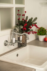 Fototapeta premium New Year's decor of modern kitchen in Scandinavian style. White light rustic kitchen close-up and copy space. Hygge kitchen details New year concept. White gray kitchen room organization. Pure water a