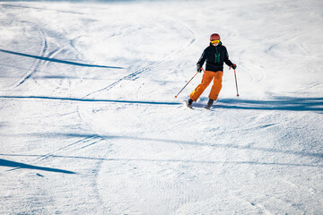Teenage skier going down the hill on a sunny day