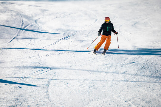 Teenage skier going down the hill on a sunny day