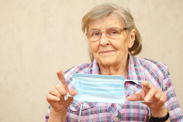 An elderly woman shows to wear a protective mask