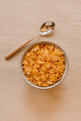 Cornflakes on a bowl on rustic background. Top view.	