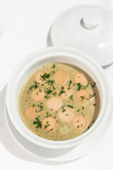 German traditional KARTOFFELSUPPE potato and sausage soup on white background
