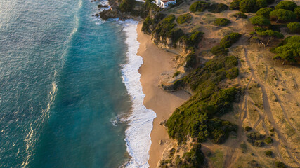 Aerial drone view of shore waves washing the sand of a marvelous paradise beach in Cadiz, south Spain