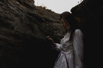  photo of girl in white dress among the mountain rocks 