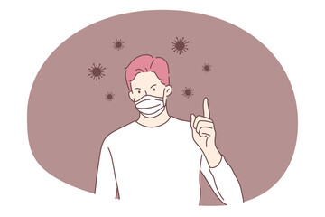 Danger or coronavirus infection epidemic, protective facial mask, pandemic concept. Young man in medical protective mask standing showing attention sign with raised finger in bacteria flowing around