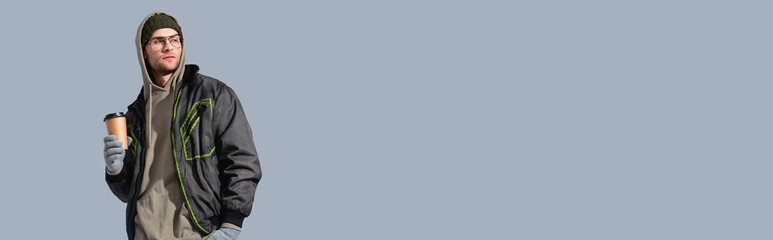 fashionable man in glasses, hat and anorak holding paper cup isolated on grey, banner © LIGHTFIELD STUDIOS