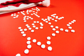 Stay home lettering from round white pills on a red background. Santa hat