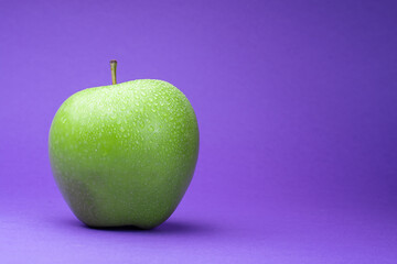 green apple on purple background 