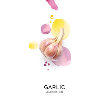 Creative layout made of garlic with watercolor spots on the white background. Flat lay. Food concept.