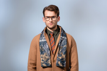 Obraz premium stylish man in winter coat looking at camera on grey