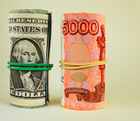 Russian rubles and American dollars rolled up in a tube isolated on a light background. World economic crisis. Cash loan.
