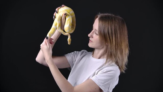 Slow motion shooting of woman with albino python in her hands