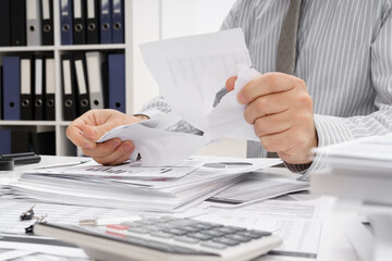 business problem concept - disappointed businessman has trouble and tears up reports