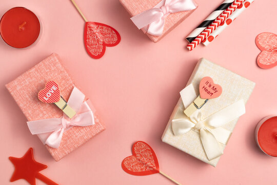 Boxes for small gifts in pastel colors on a pink background with place for text. Advertising, poster.