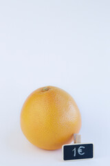 One grapefruit against white background with copy space and a little chalkboard with its price (euro)
