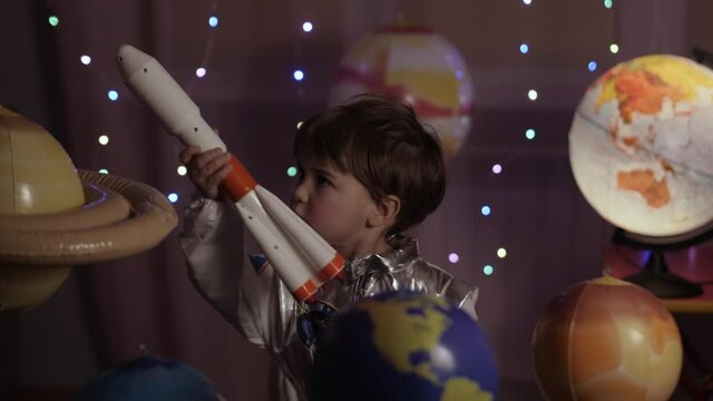 Space Travel Spaceship. Creative Little Kid Boy Astronaut Launching Rocket From Spaceport Through Planets. Child Dreamer Playing Toy Space Rocket Flying Among Planets. Spaceman Fantasy Flying on Space