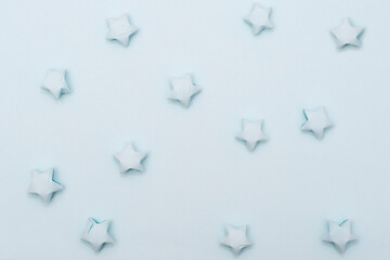 Solid light blue background with paper stars in a children's style. Template for scrapbooking.