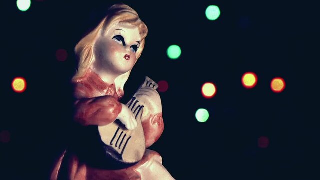 Natale vintage, bambola bambina che suona con luci a intermittenza colorate.
