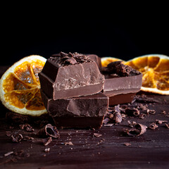 Organic food snack tasty sweet dessert milk dark chocolate bar macro closeup broken slide piece and fruit orange raspberry hazelnut nuts on cocoa cacao powder wooden table for new year Christmas gift