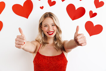 Positive blonde woman in red dress showing thumbs up