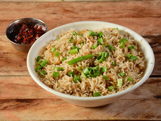 Indian cuisine Healthy and tasty chicken fried rice with tomato sauce served in white bowl over a...