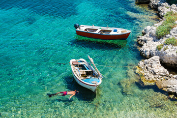 Obraz premium A fishing boat on the sea and Its shadow seen at the bottom easily in Kokkari village.