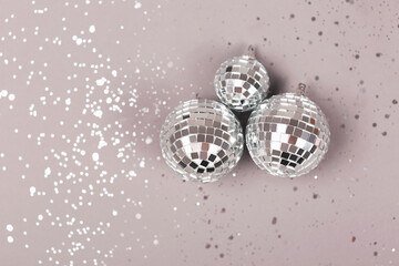 Minimal Christmas and New Year background. Disco balls on grey backdrop. Decorated with glitter. Copy space for your text.