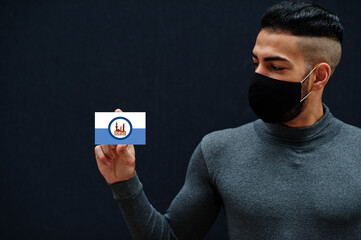 Egyptian man in gray turtleneck and black face protect mask show Cairo flag isolated background. Governorates of Egypt coronavirus concept.