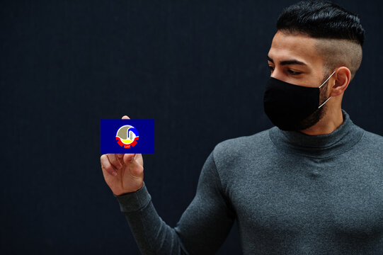 Egyptian man in gray turtleneck and black face protect mask show Beheira flag isolated background. Governorates of Egypt coronavirus concept.