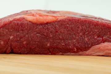 a piece of marbled beef breast on a wooden cutting board lying on a canvas