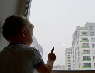 Beautiful baby boy with child face posing photographer near window