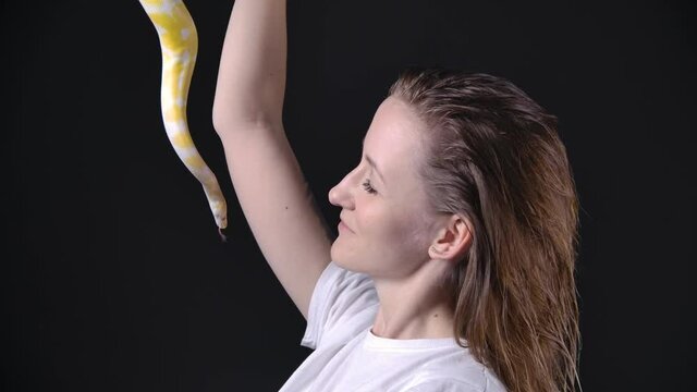Slow motion footage of woman putting up albino python