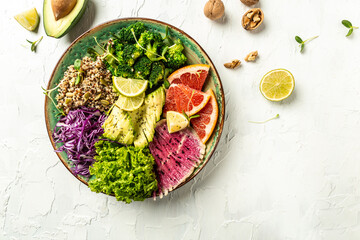 Healthy salad with quinoa, micro greens, avocado, grapefruit, broccoli, watermelon radish, red cabbage. Food recipe background. Close up