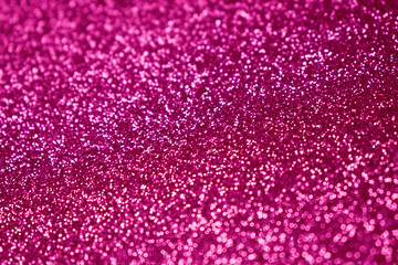 Pink glitter, blurred effect. Fuchsia color. Glowing holiday light circles are created from bokeh...