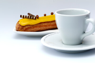 Eclair with custard and lemon glaze on a white background. Confectionery for the sweet tooth.