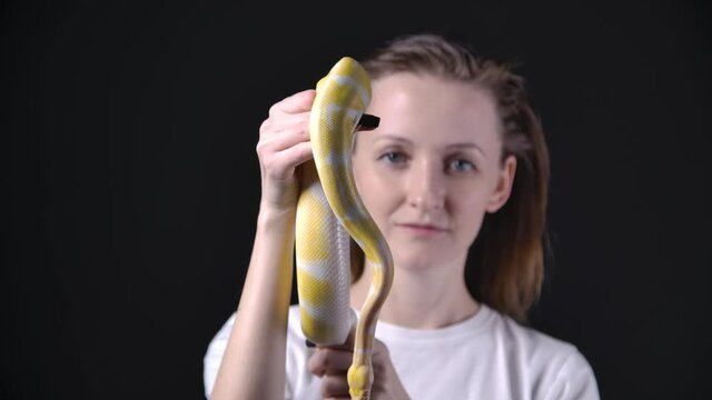 Slow motion shooting of girl holding albino python