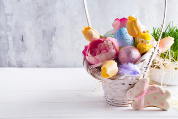 Easter basket filled with colorful hand painted Easter Eggs over a light background