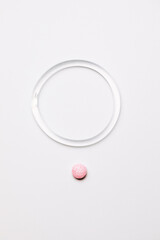  hormone ring and tablets on a white background. Contraceptive ring