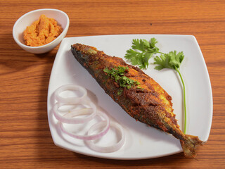 The Indian mackerel (Rastrelliger kanagurta) , Bangda fry, Fish fry.. on a rustic wooden...